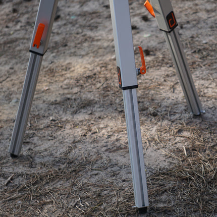 Three metal stakes with orange accents on a sandy surface