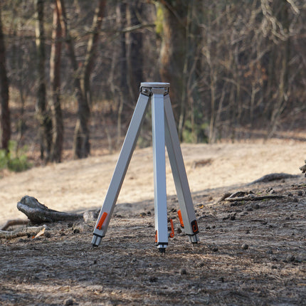 Surveying tripod in a forest setting
